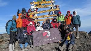 https://images.followalice.com/2krc2LHTrDCxNt9mbISN0N/b5c02ad68bdbc685d2c7c564e645f989/Group_pic_Kilimanjaro_summit_Uhuru_Peak_Follow_Alice_flag_group_of_11_all_summitted.jpg?f=center&fit=fill&fm=jpg&h=900&w=1600